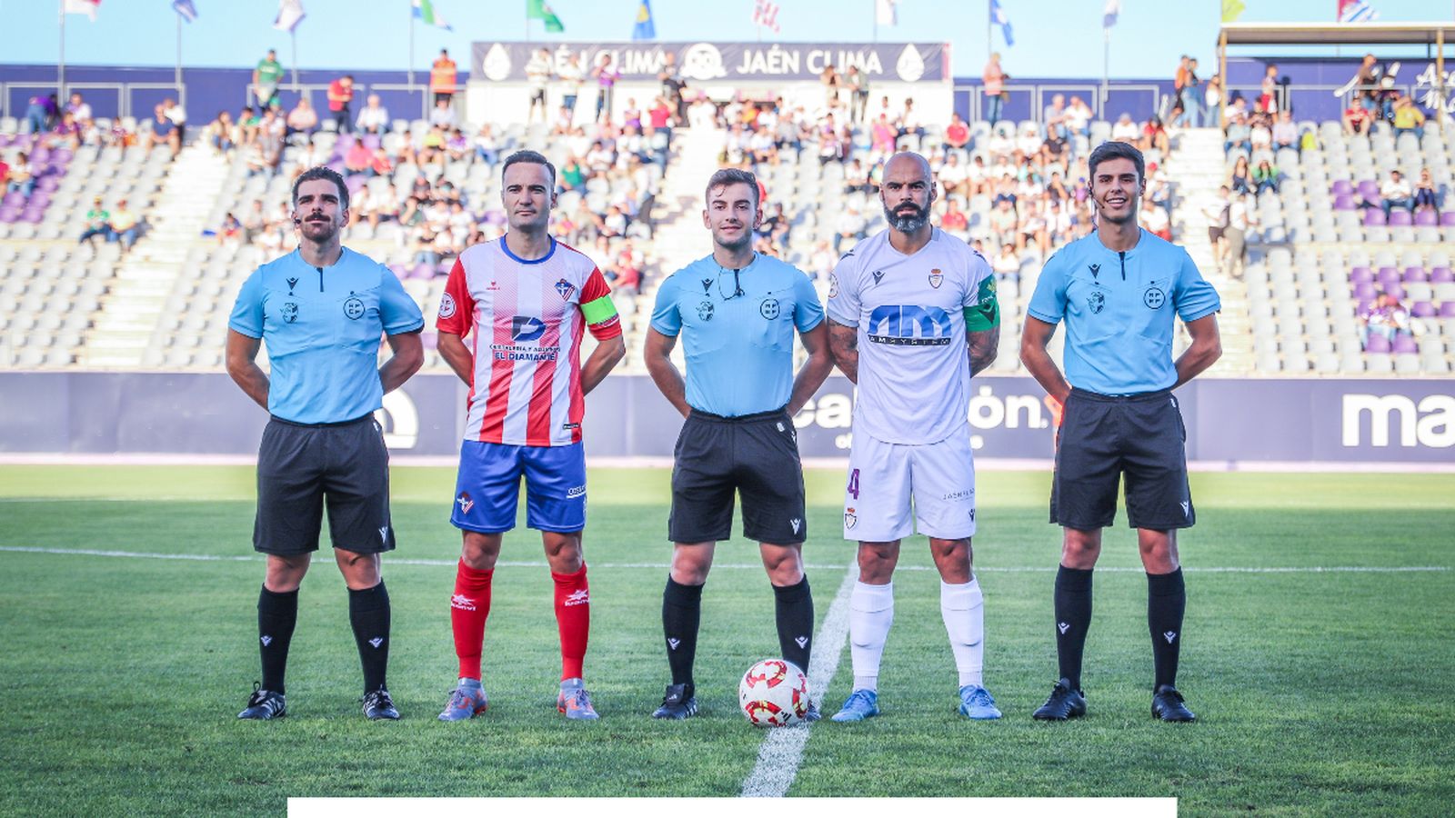 Los capitanes de ambos equipos posan junto al trío arbitral antes del comienzo del encuentro en La Victoria.