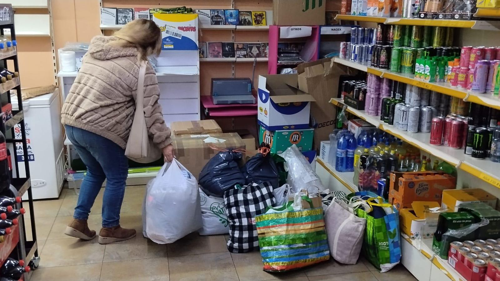 Una mujer dejando ropa para donarla a la familia en la tienda Ratoncito Pérez de Las Gabias