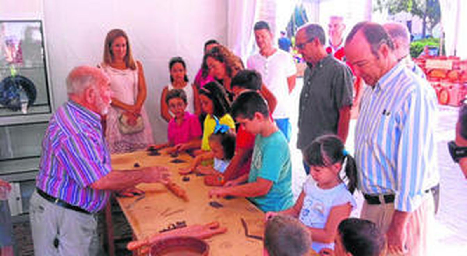 El alcalde de Almería, Luis Rogelio Rodríguez-Comendador, se acerca a comprobar el gran éxito del taller de alfarería de Francisco Robles en la Rambla Federico García Lorca.