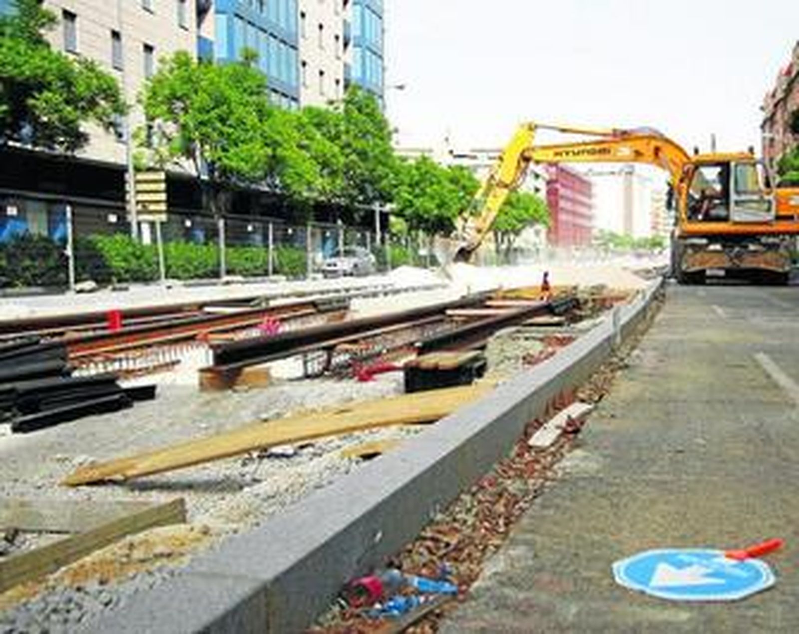 Una excavadora echa material sobre las vías del tranvía en la Enramadilla.