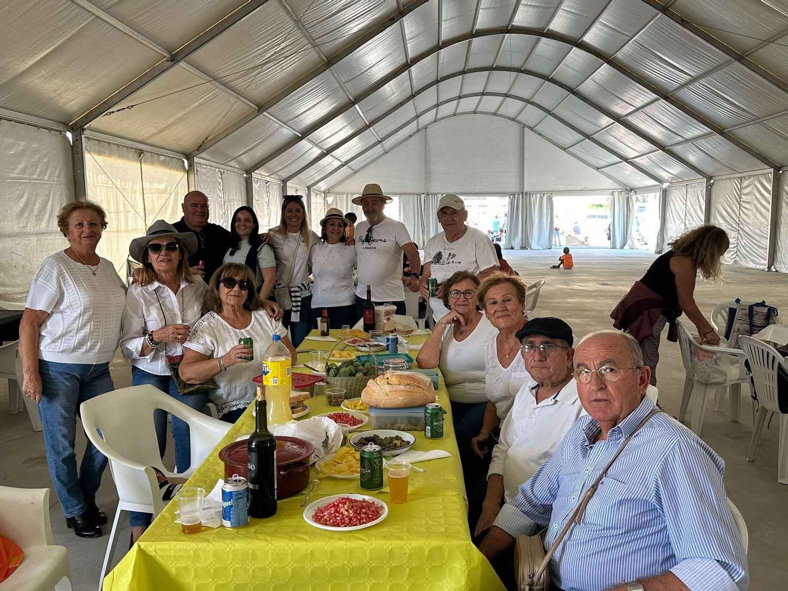 Algunos asistentes sentadas a la mesa para degustar las migas.