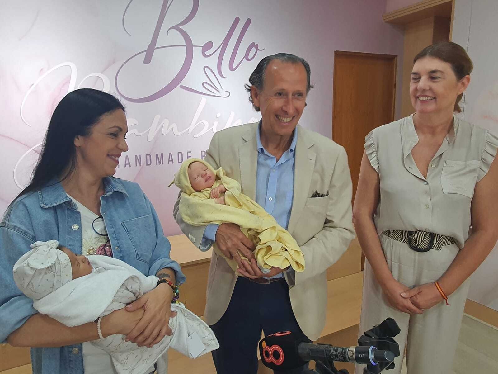 El alcalde, con los bebés reborns durante su visita al comercio.