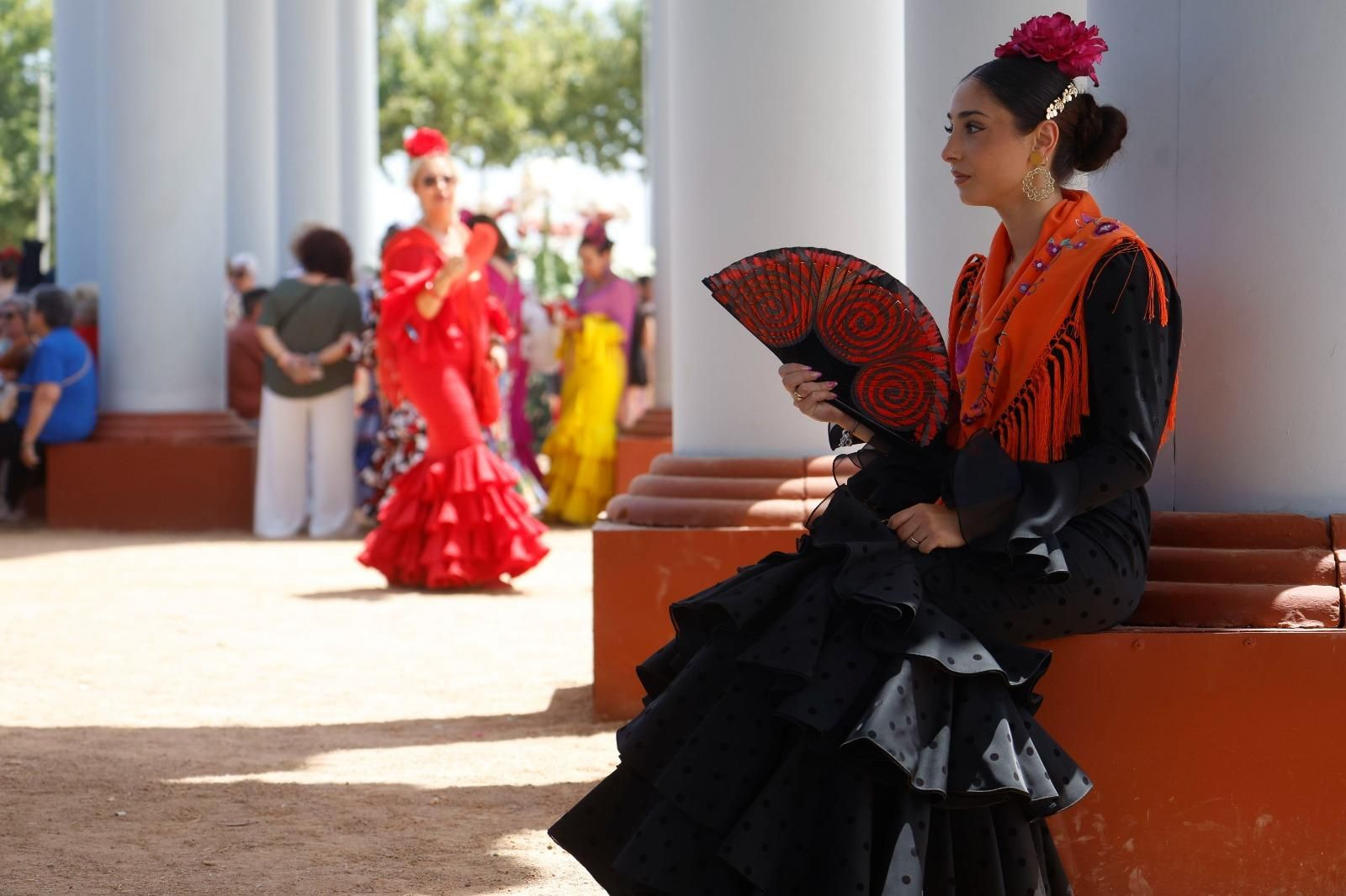 Una mujer se protege del calor en la portada de la Feria