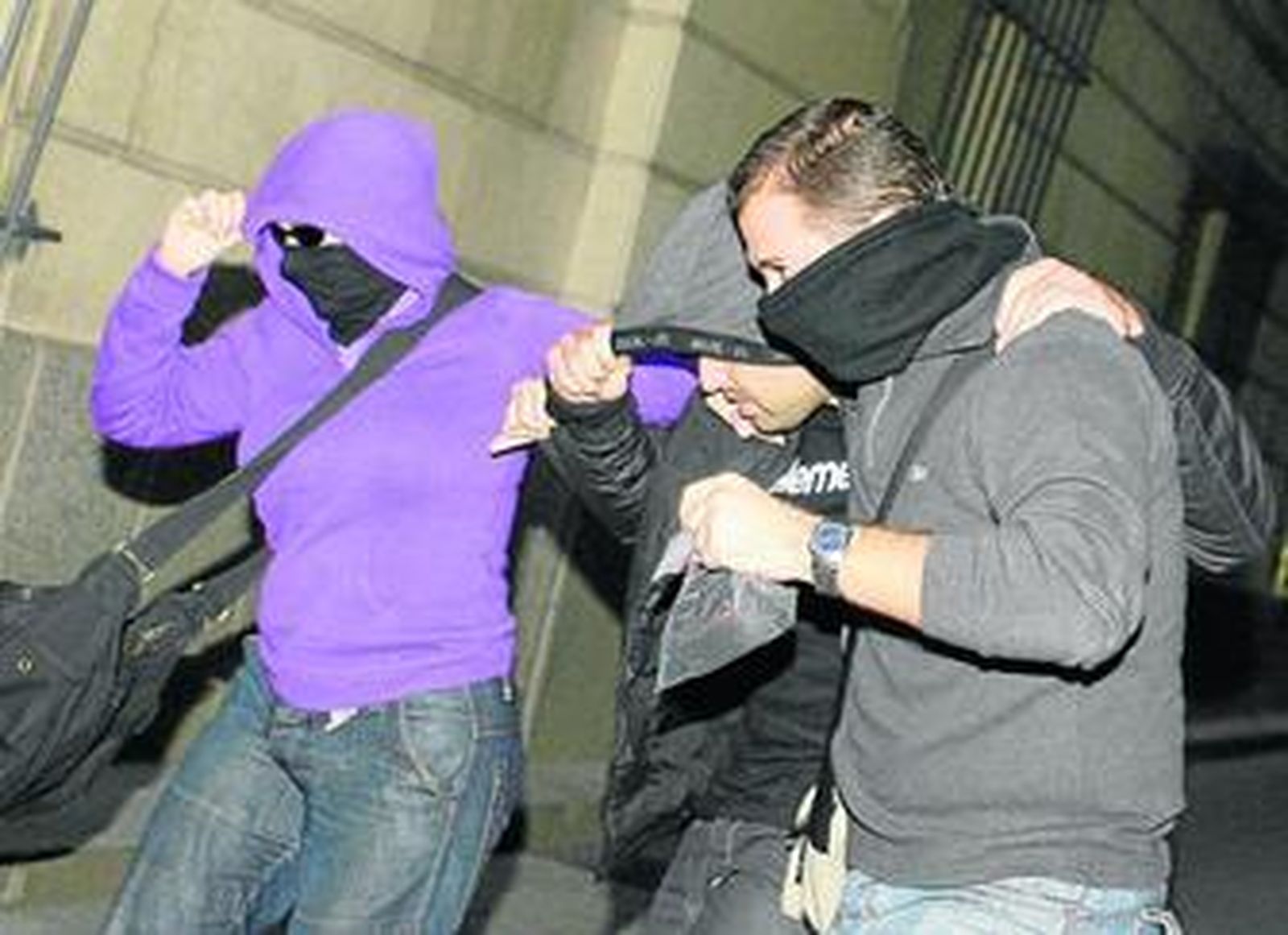 El policía nacional Sergio O. es escoltado ayer por otros dos policias hasta el juzgado de guardia.