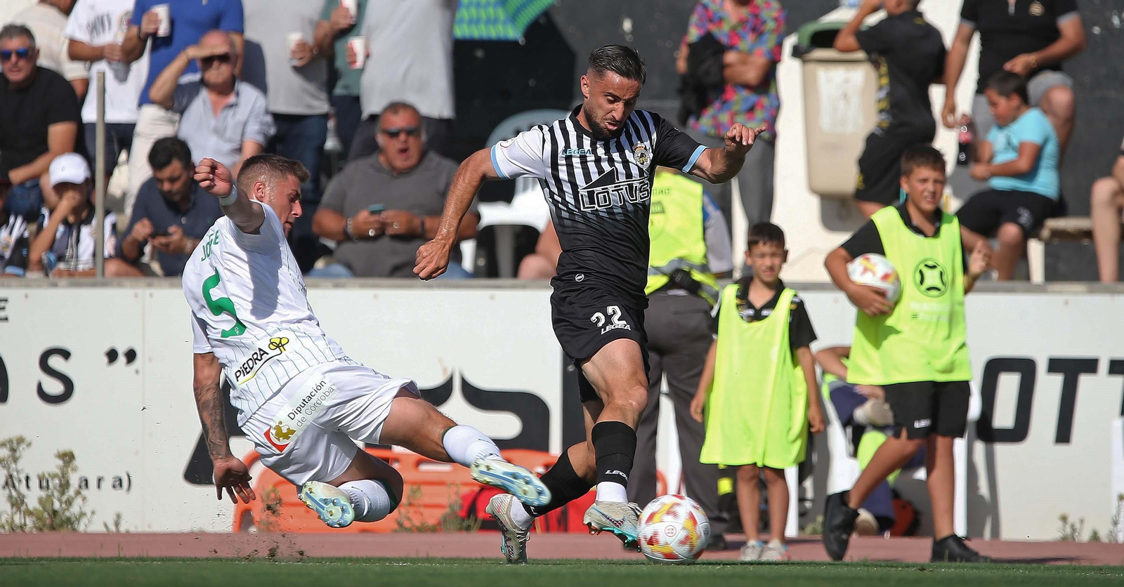 Jorge Moreno frena en falta a Omar Perdomo en la acción que le costó la amarilla en el Balona - Córdoba CF.