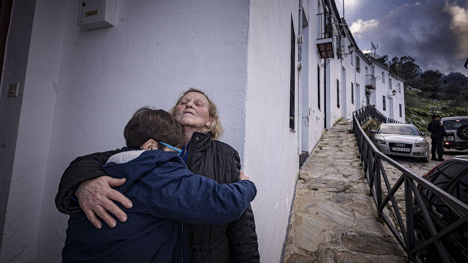Una abuela abraza a su nieto a la puerta de su casa tras regresar a Grazalema