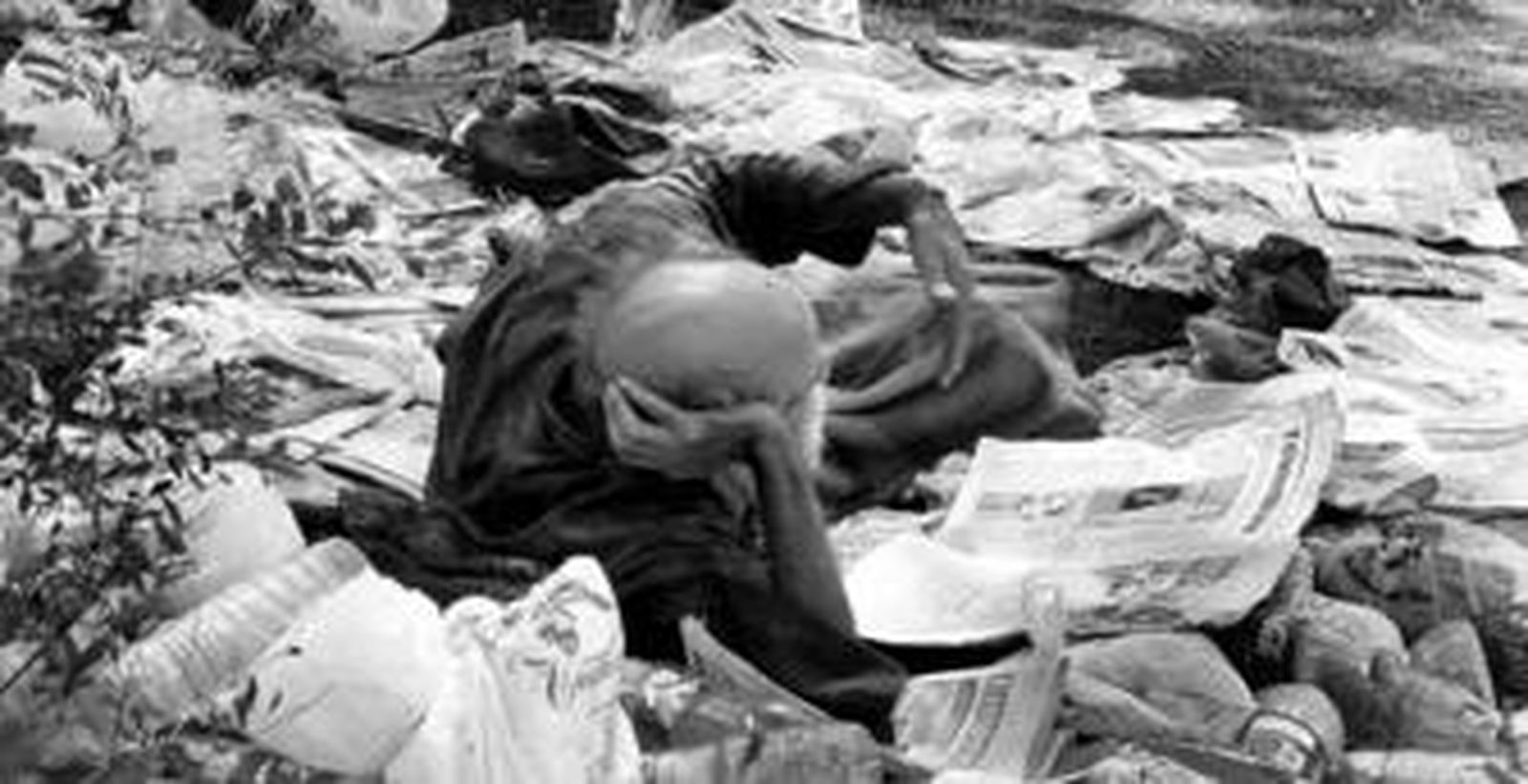 Ángel B.M., leyendo el periódico entre basuras en el pinar de las Dunas de San Antón hace tan solo unos días.