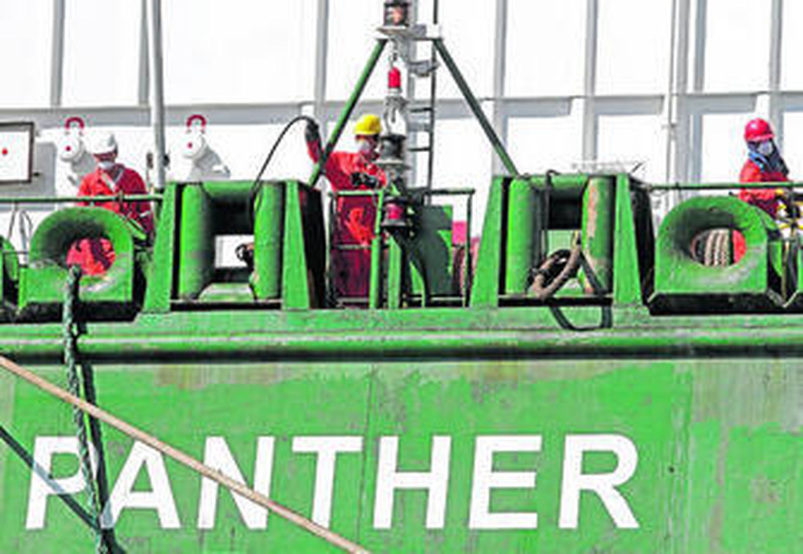 Tripulantes del 'Panther' trabajan con mascarillas durante el atraque en el dique norte del puerto de Algeciras.