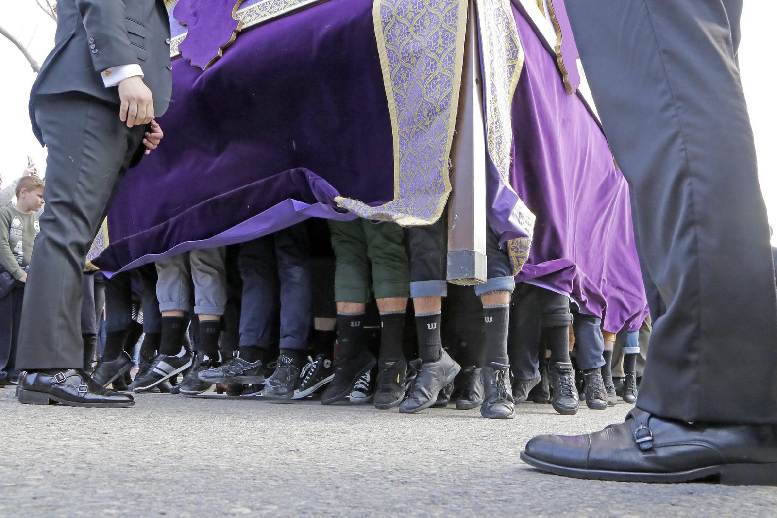 Una cuadrilla de costaleros levanta al cielo un paso de misterio tras la llamada de los capataces.