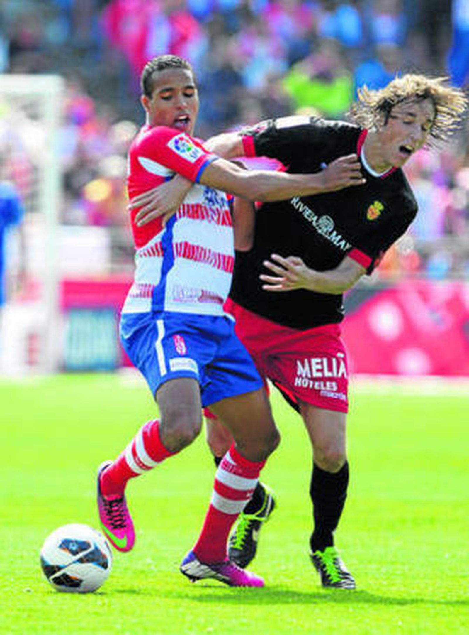 El Arabi y Pina pelean por un balón.