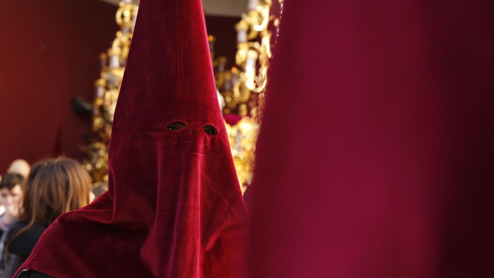 Los Favores visten túnica negra y antifaz burdeos, con botonadura y cíngulo en el mismo color