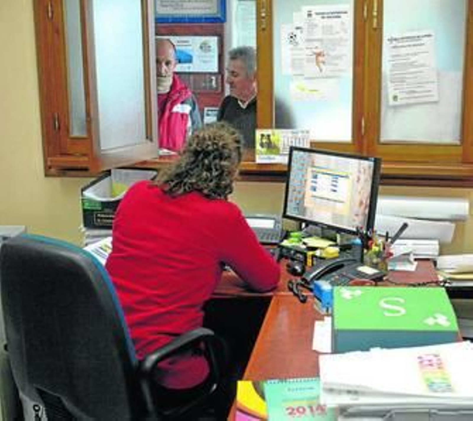 Una empleada municipal atiende al personal.