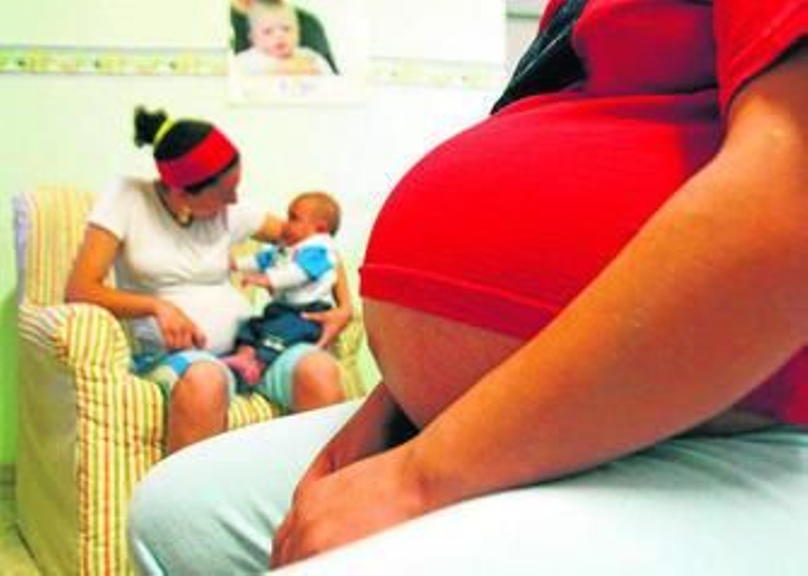 Una mujer embarazada y una joven madre con su bebé.