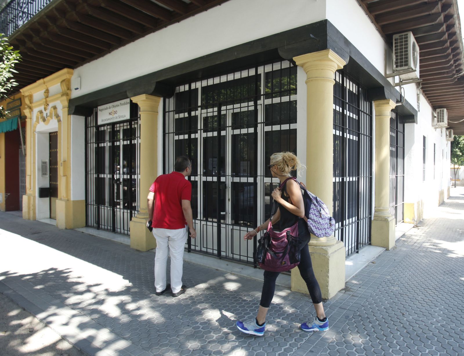 Un hombre mira hacia el interior de la oficina, cerrada al público