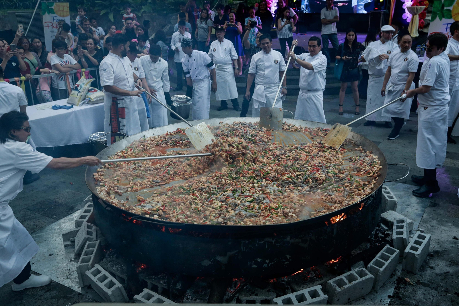 Cocineros elaboran la gran paella en Manila.