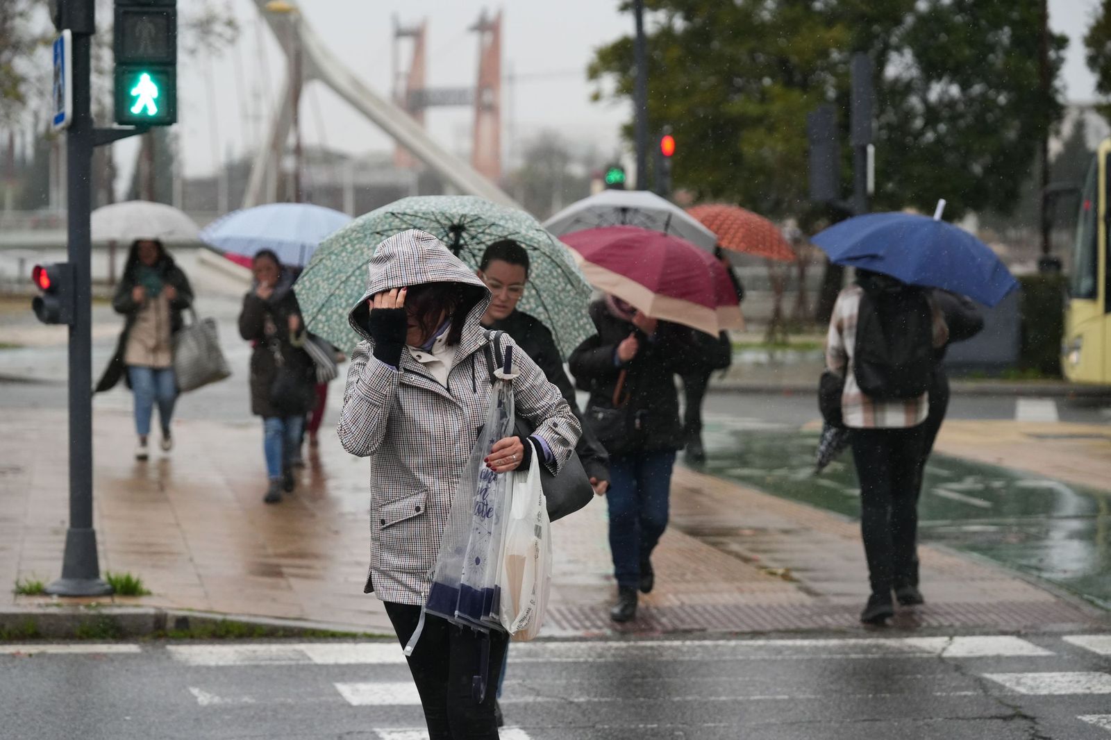 Varias personas bajo la lluvia en Sevilla.