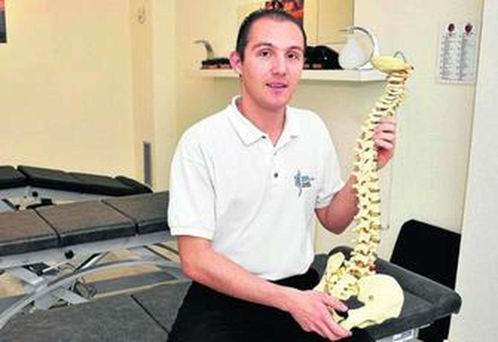 El especialista en quiropráctica Thomas Madteossian posa en su colsultorio ubicado en la calle Larga de Jerez junto a una réplica de la columna vertebral.