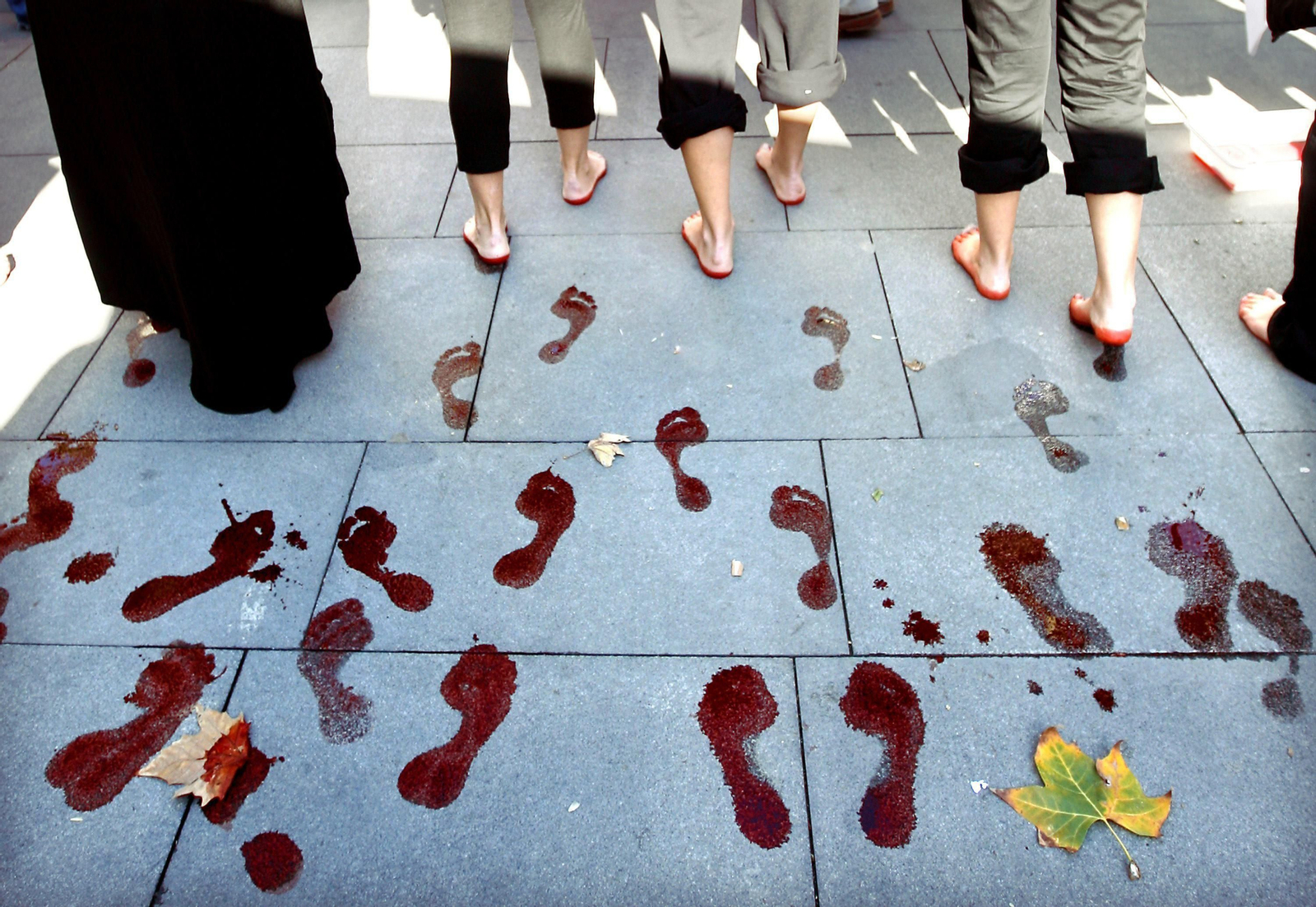 Varias mujeres dejan las huellas de sus pies teñidos de rojo durante una manifestación en Sevilla. Varias mujeres dejan las huellas de sus pies teñidos de rojo durante una manifestación en Sevilla.