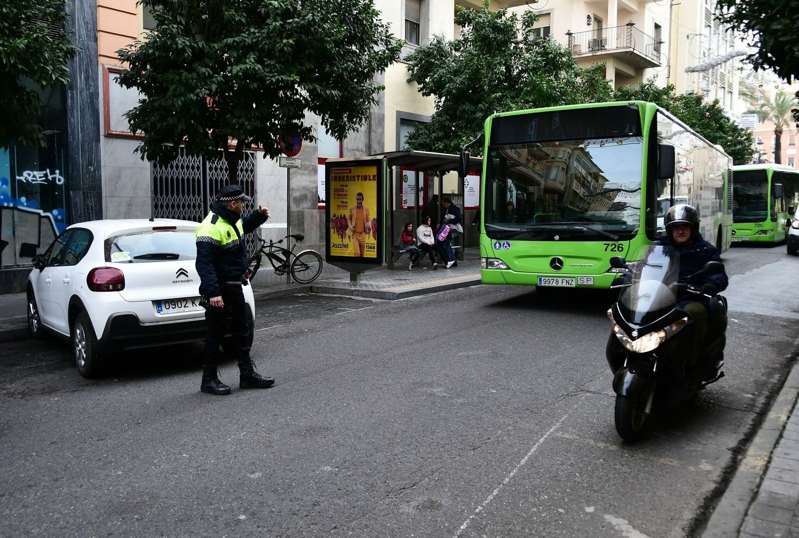 Un policía local da paso a un autobús de Aucorsa.