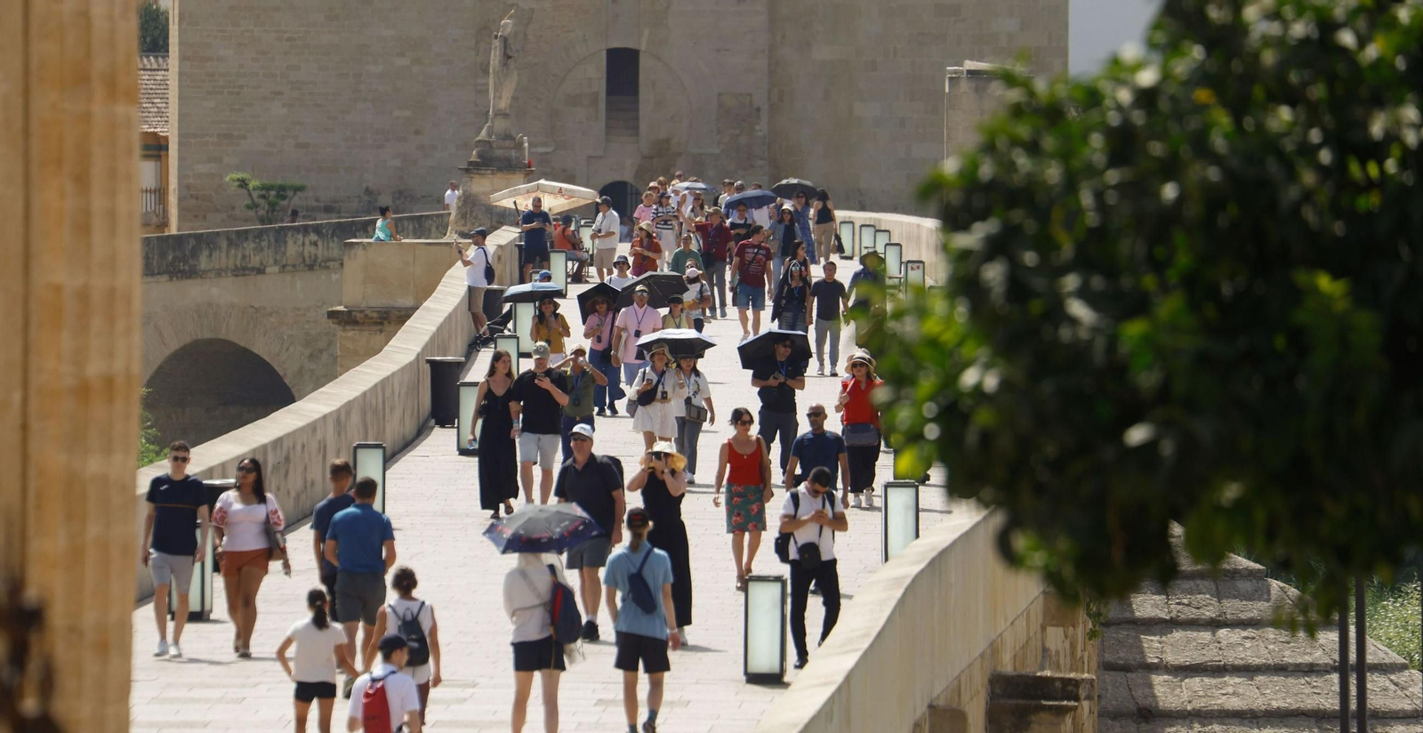 Turistas se protegen del sol con paraguas mientras pasean por el Puente Romano de Córdoba. Turistas se protegen del sol con paraguas mientras pasean por el Puente Romano de Córdoba.