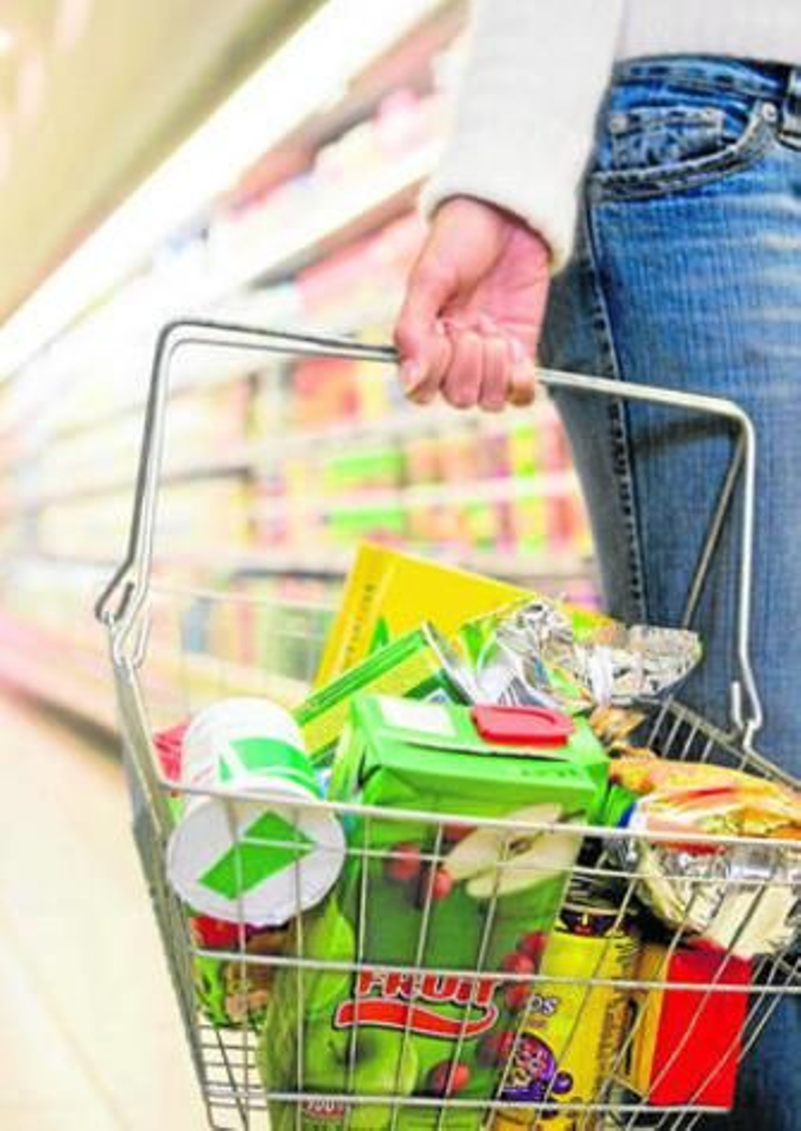 Una persona porta una cesta con productos en un supermercado.