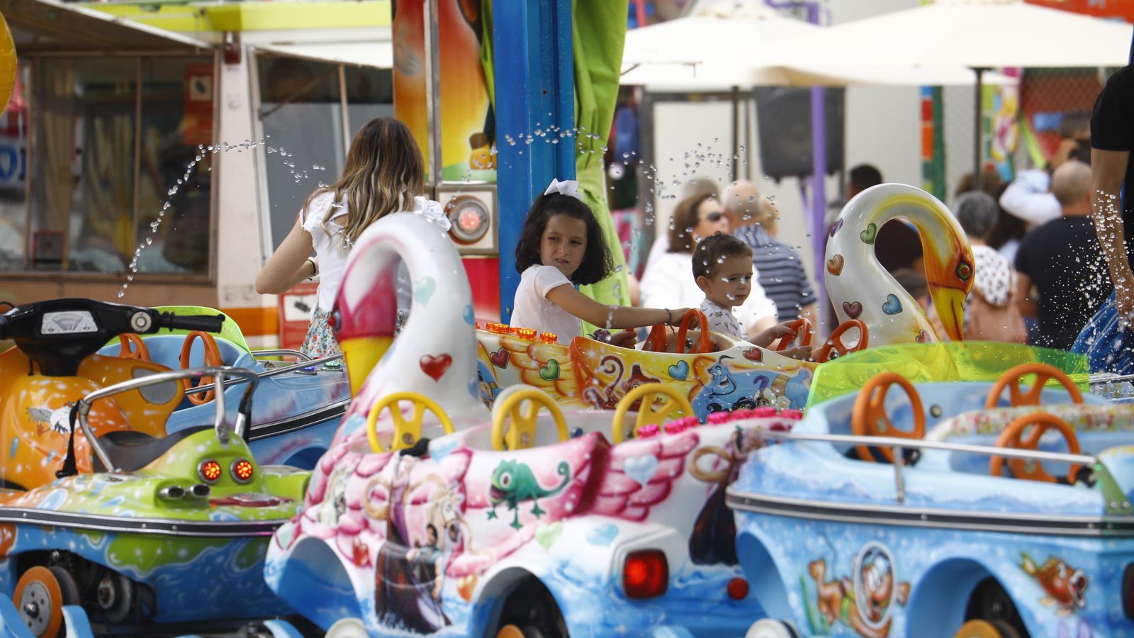 Varios niños disfrutan de uno de los 'cacharritos' de la Feria.
