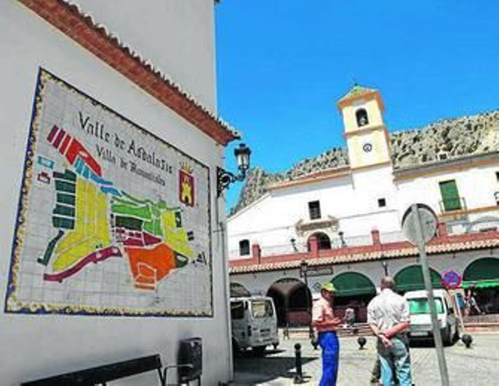 Dos hombres conversan en una plaza del Valle de Abdalajís.