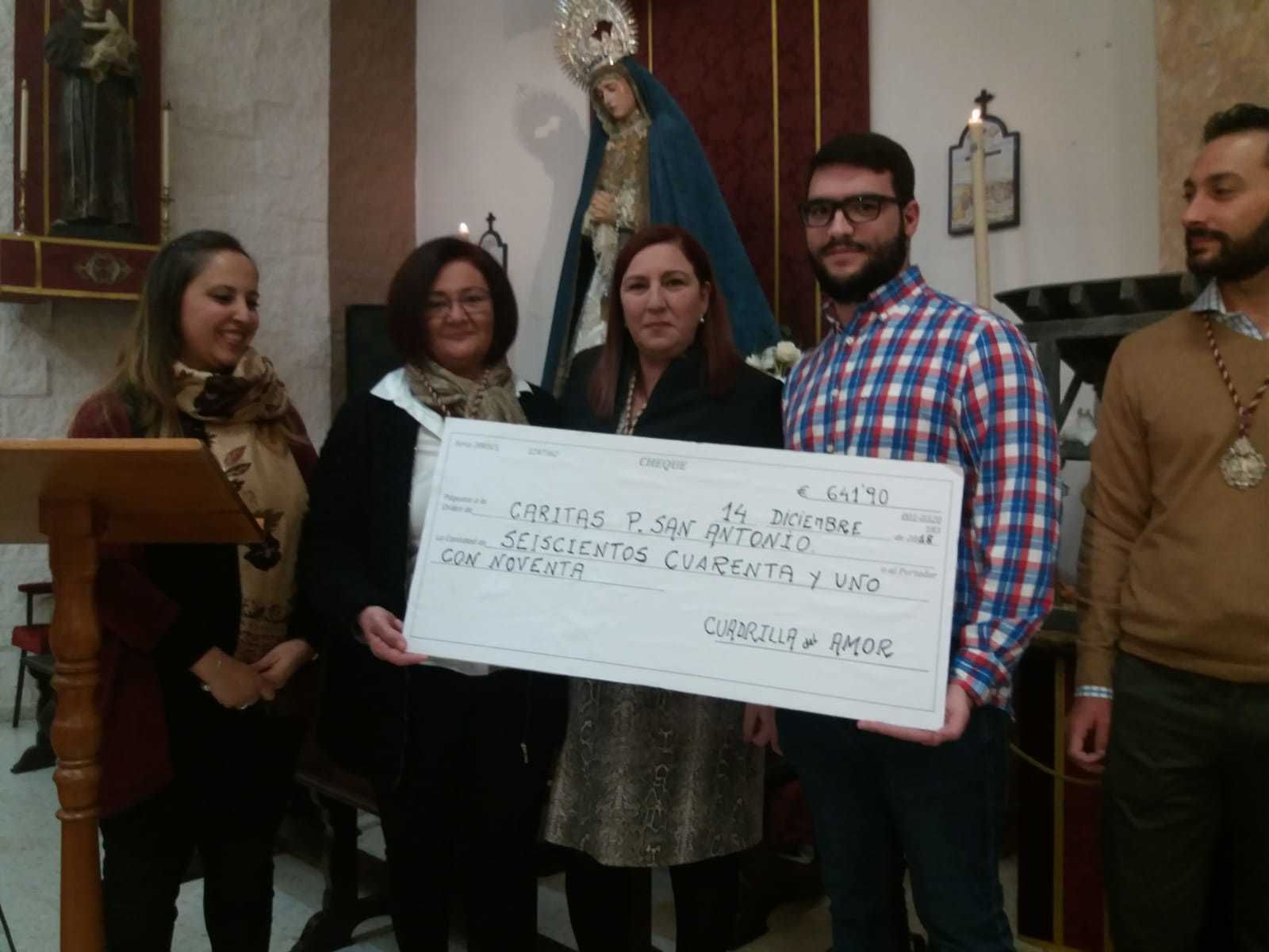 Representantes de la cuadrilla de costaleros hacen entrega de un cheque simbólico a la hermandad.