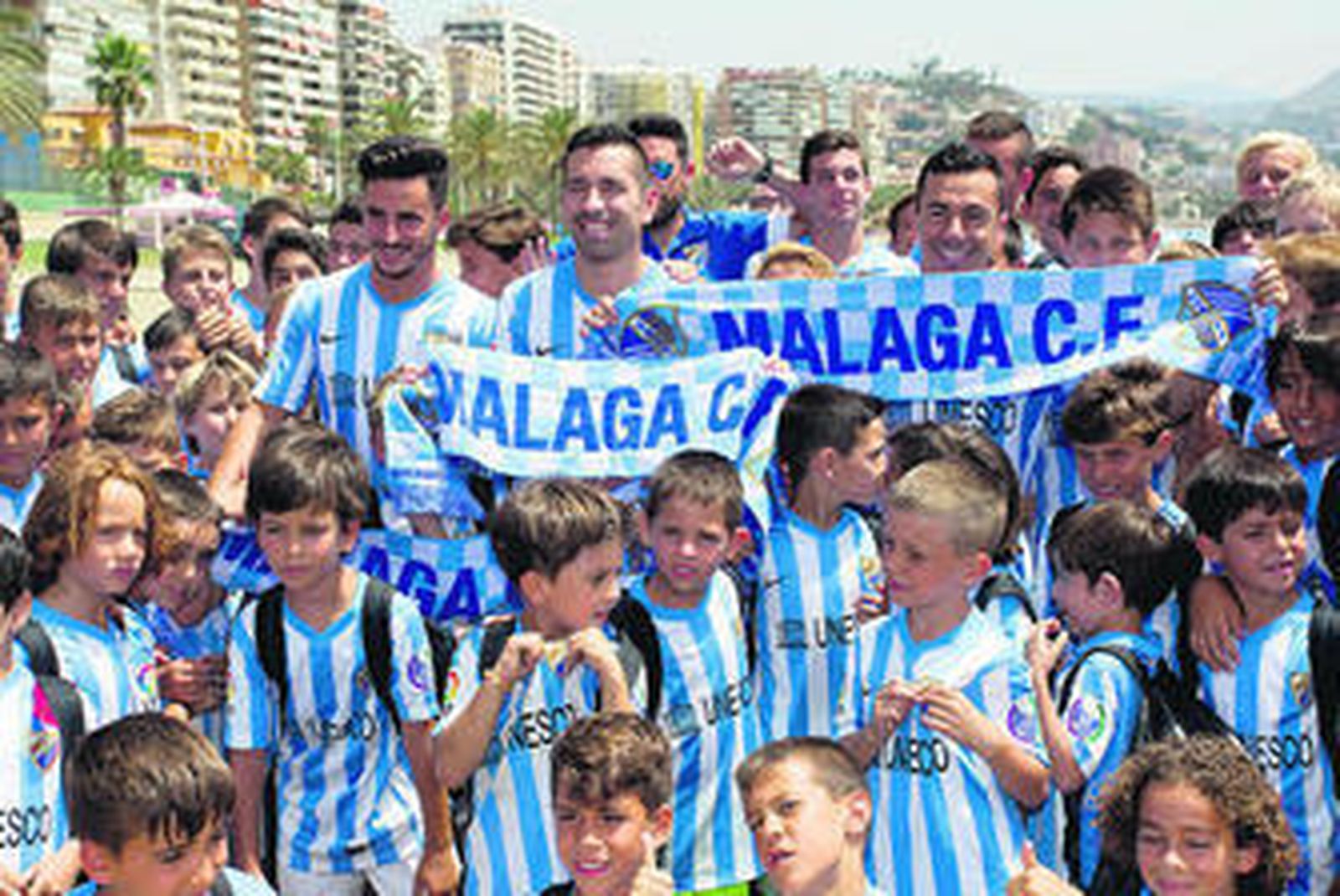 Juan Carlos, Charles y Espinho, con los chicos del Campus del Málaga en La Malagueta, ayer.