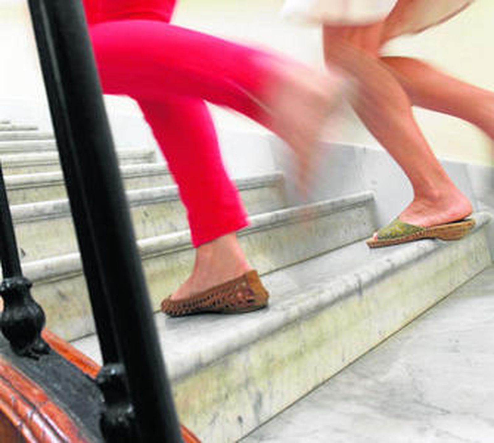Dos mujeres suben por las escaleras en su centro de trabajo.