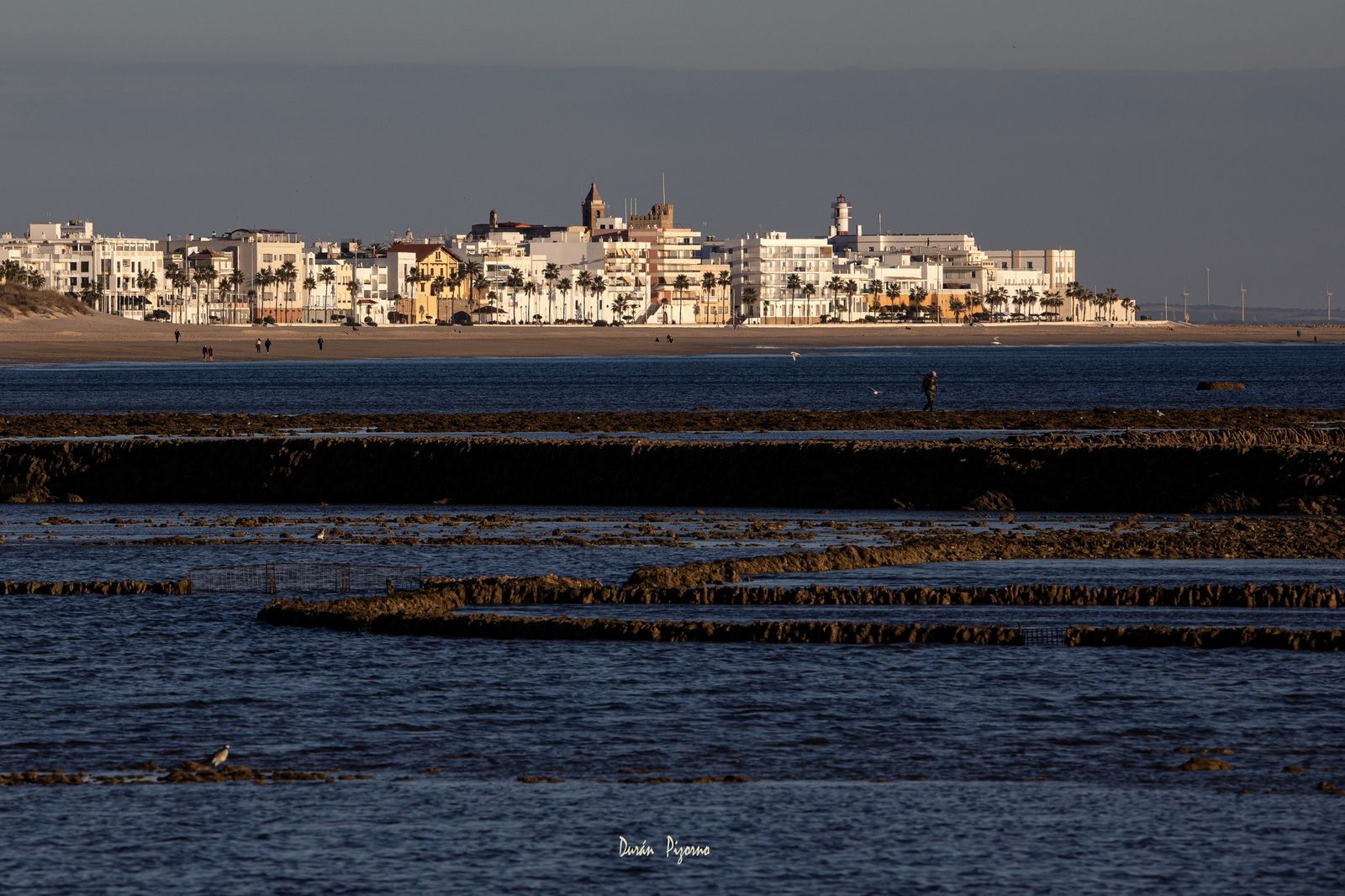 Espectacular panorámica de los corrales de pesca con el casco antiguo y la playa de La Costilla al fondo. Emilio Durán Pizorno