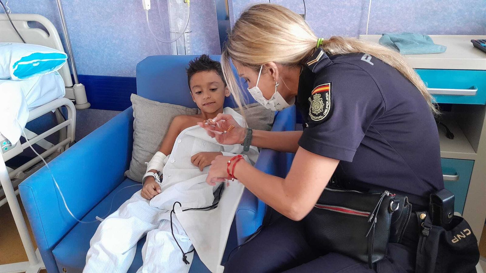 Policía entrega una pulsera con emblema a niño hospitalizado