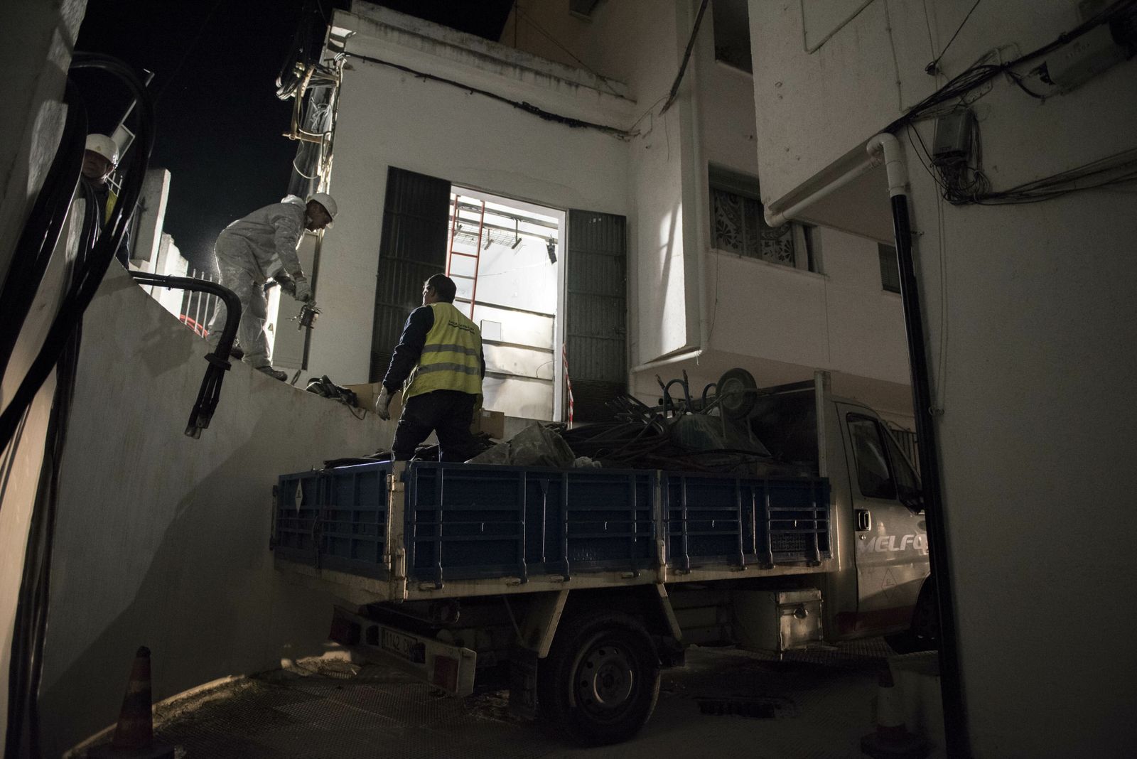 Imagen de archivo de dos operarios trabajando en un transformador durante un corte de luz.