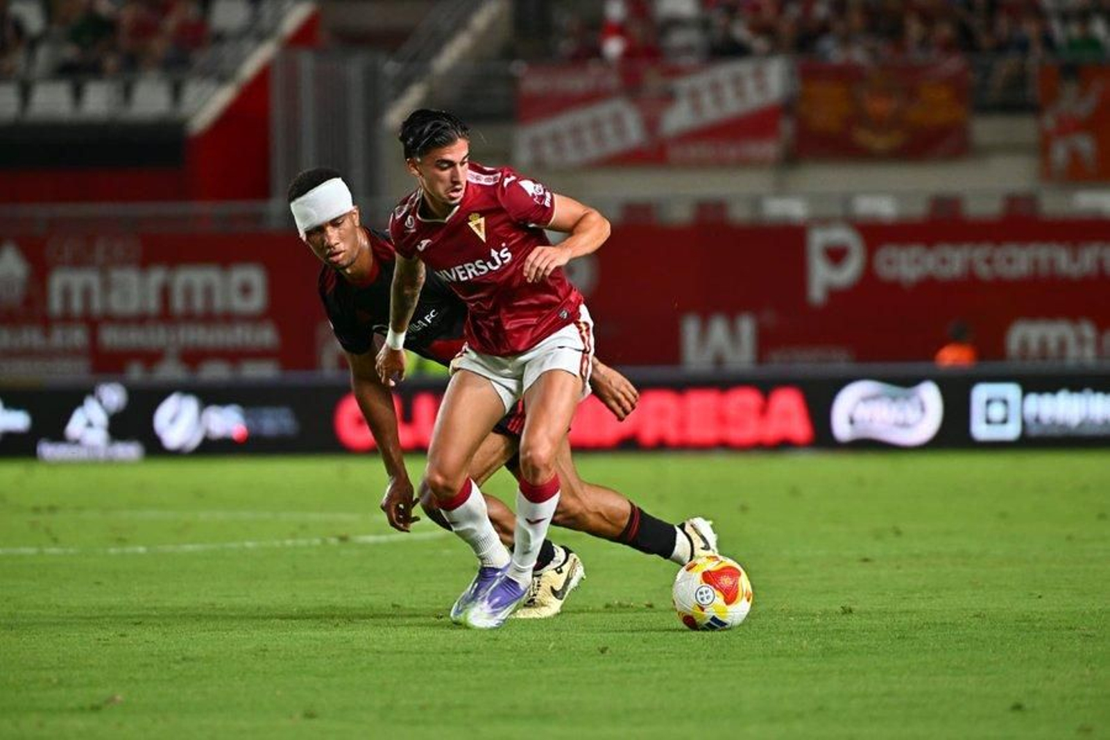 Miguel sigue a un atacante del Murcia con un vendaje en la cabeza tras un golpe.