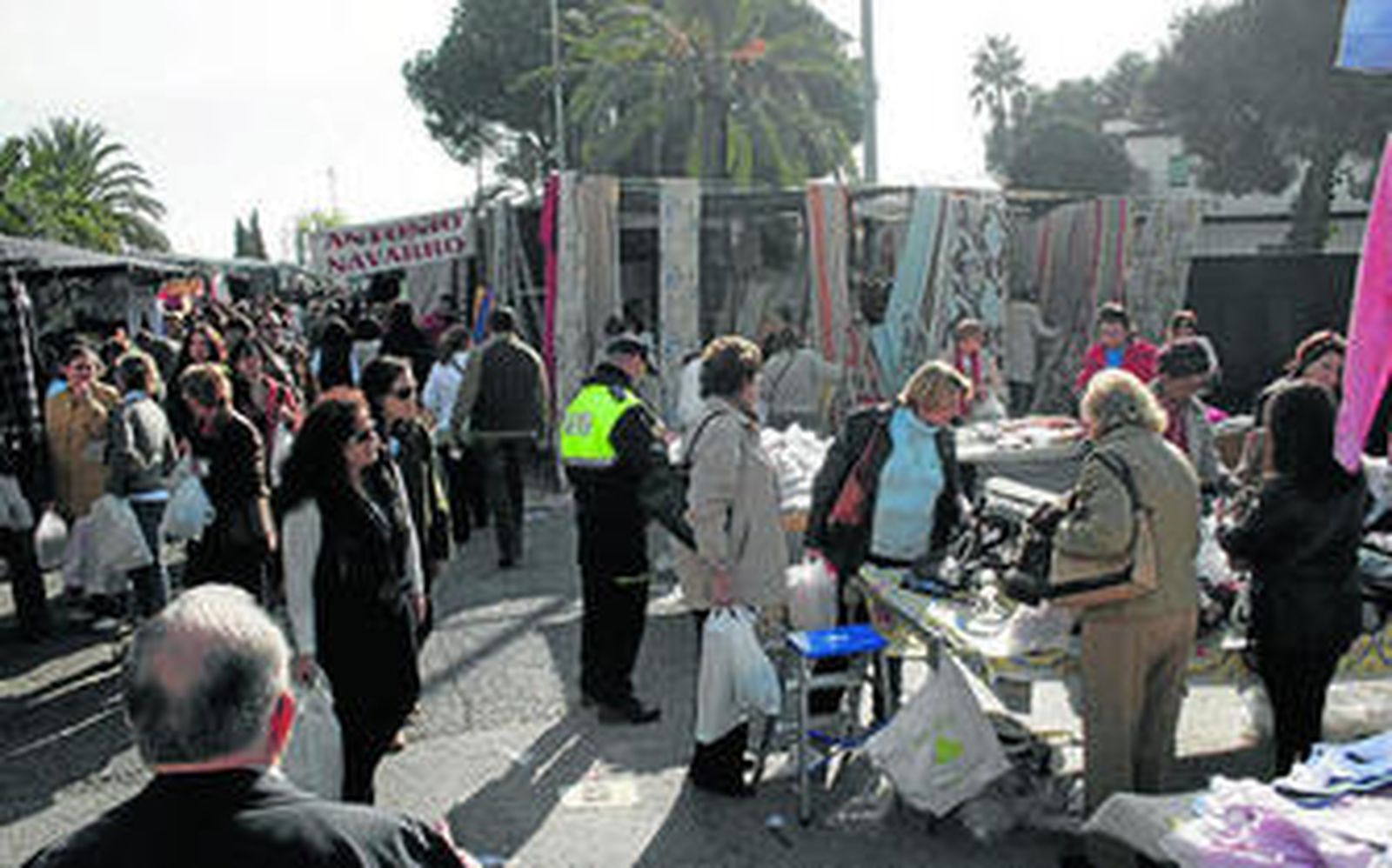 Un policía local revisa uno de los múltiples puestos instalados en el mercadillo de los martes.