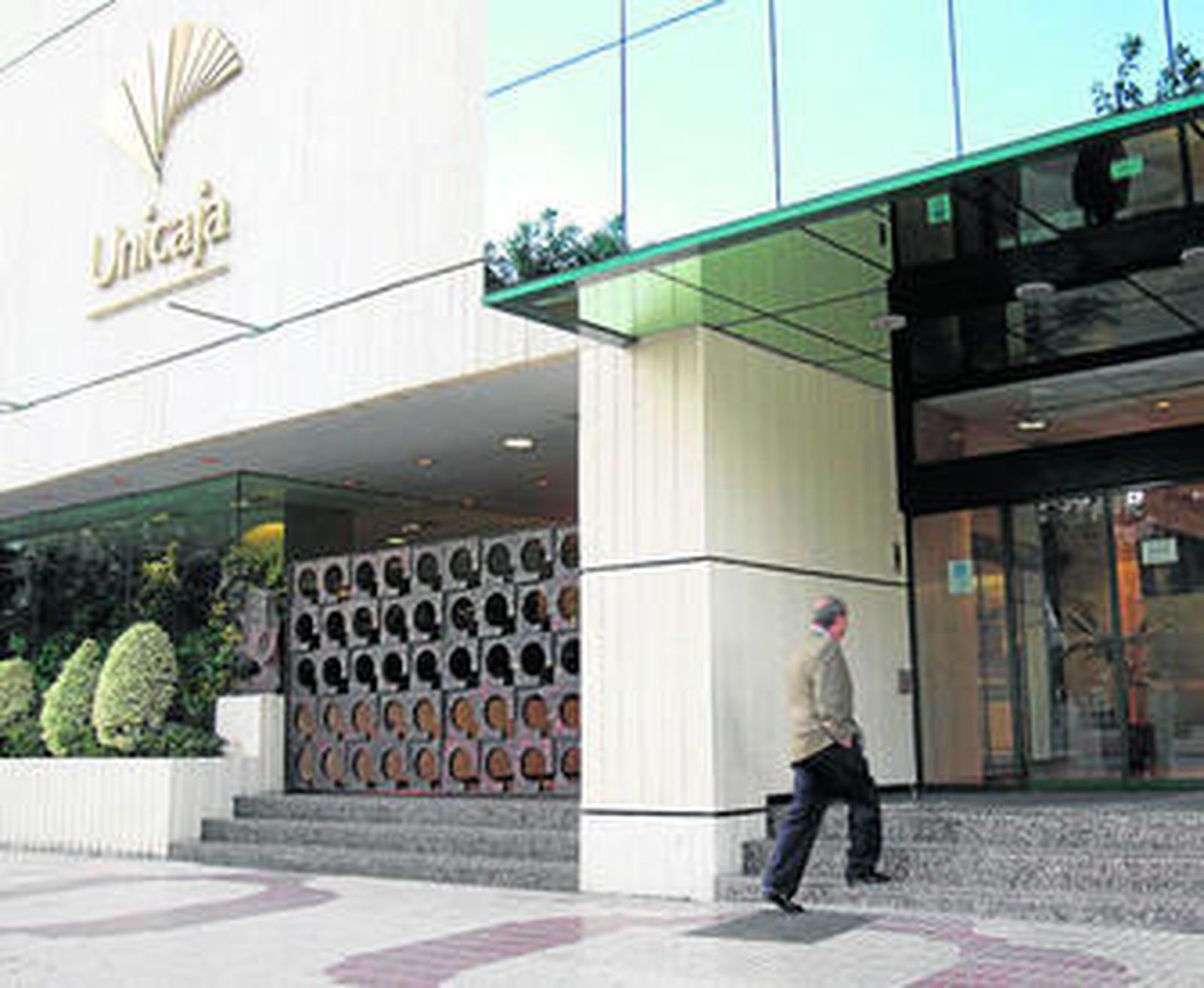 Un cliente entra en la sede central de Unicaja en la Avenida de Andalucía.