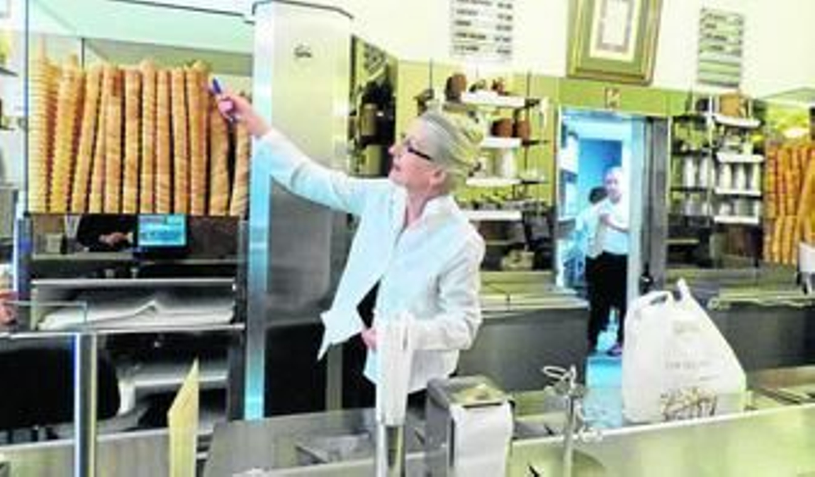 Paola de Rocco señala los carteles donde se muestran los sabores de los helados.