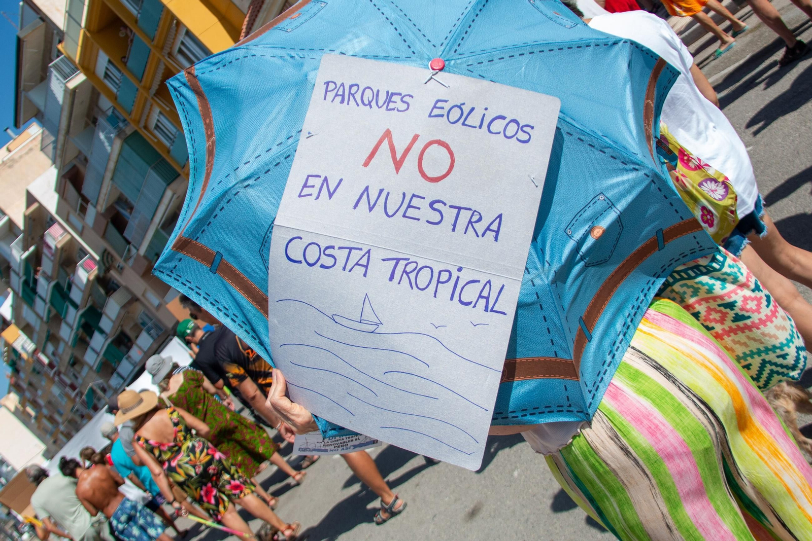 Una mujer muestra un cartel en contra de los parques eólicos en la costa