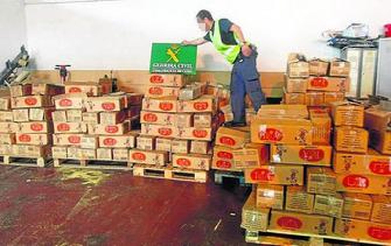 Un agente, apilando las falsas cajas de cuscús con hachís en realidad.