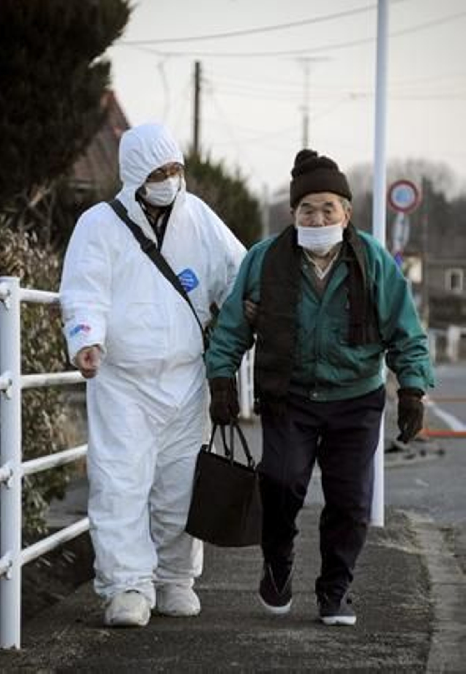 Un voluntario acompaña a un anciano hacia un refugio.