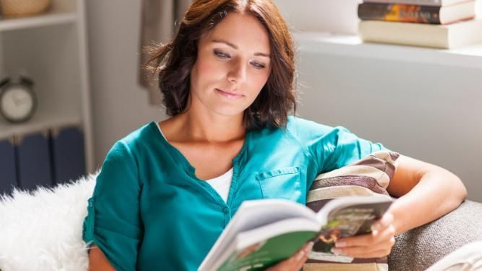 Mujer leyendo sentada en el sofá.