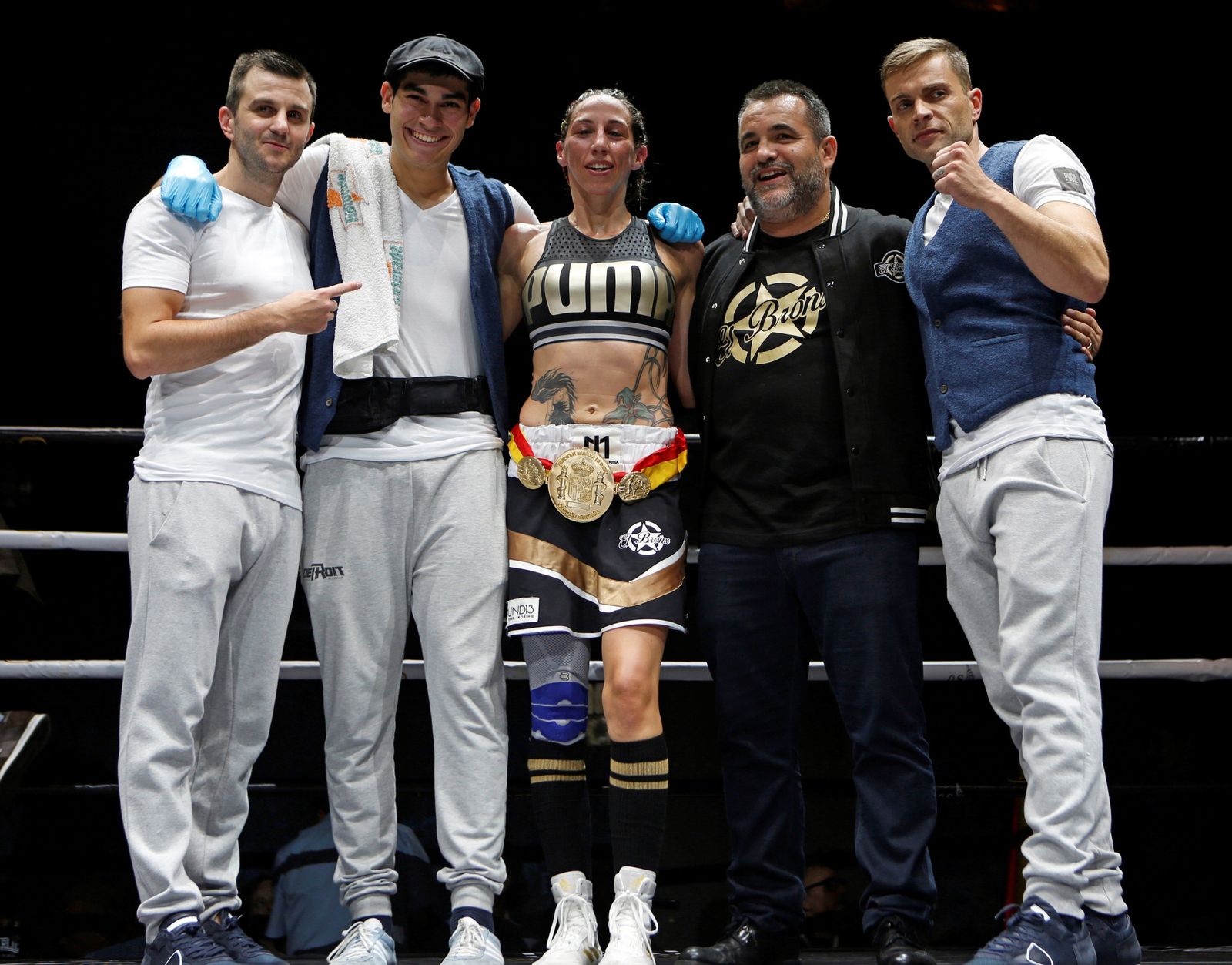 Jennifer Miranda, con el cinturón de campeona, posa con los miembros de su equipo