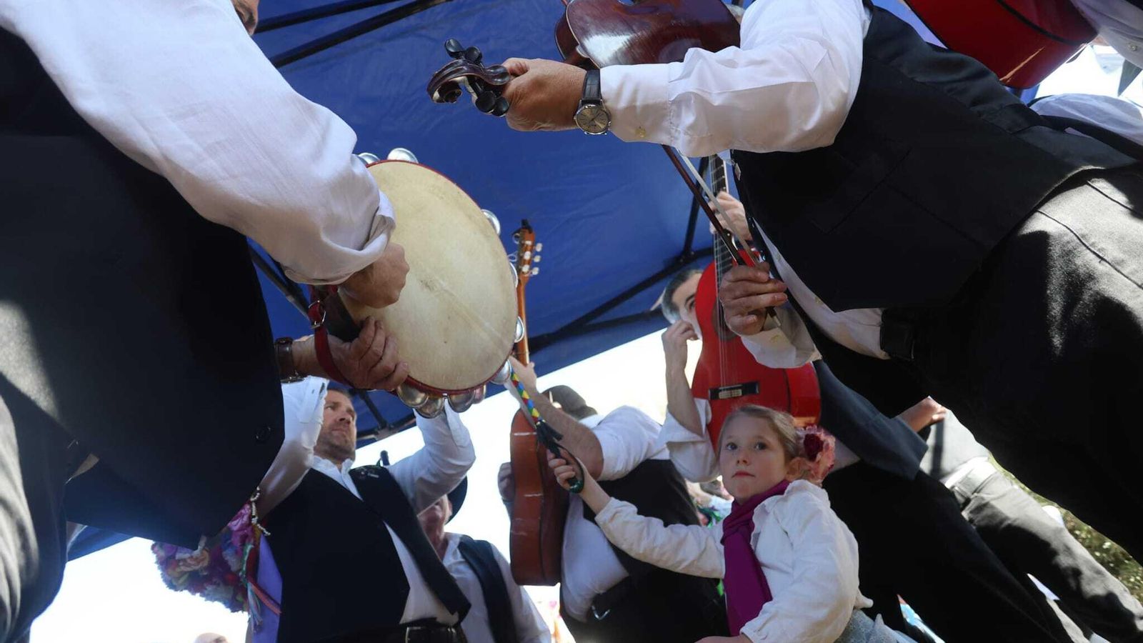 Una niña sujeta la vara de mando entre panderos, violines y guitarras. Una niña sujeta la vara de mando entre panderos, violines y guitarras.