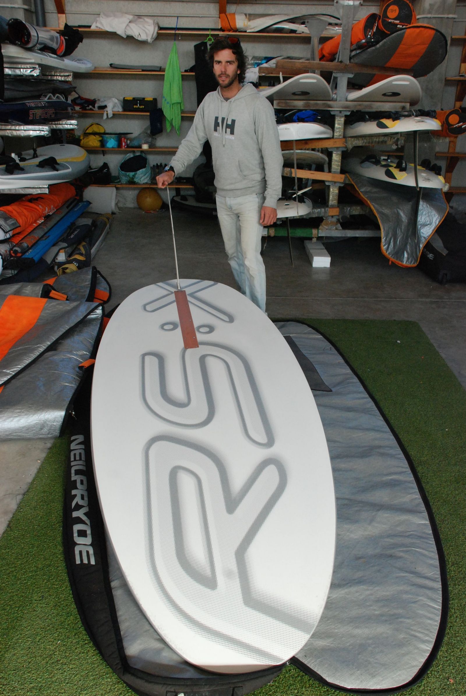 Juan Manuel Moreno posa junto a una tabla de su clase, la RS:X.