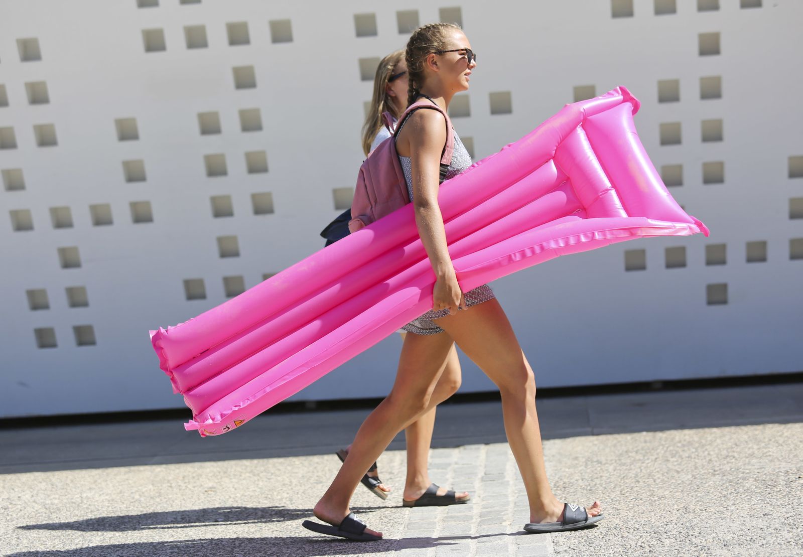 Dos jóvenes turistas pasean por el Muelle Uno camino de la playa