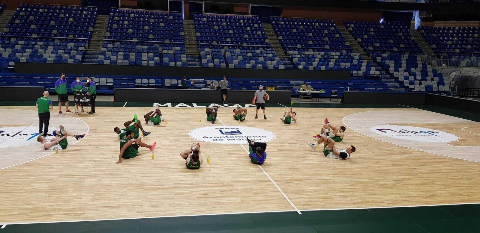 Los jugadores del Unicaja estiran hoy en el Carpena.