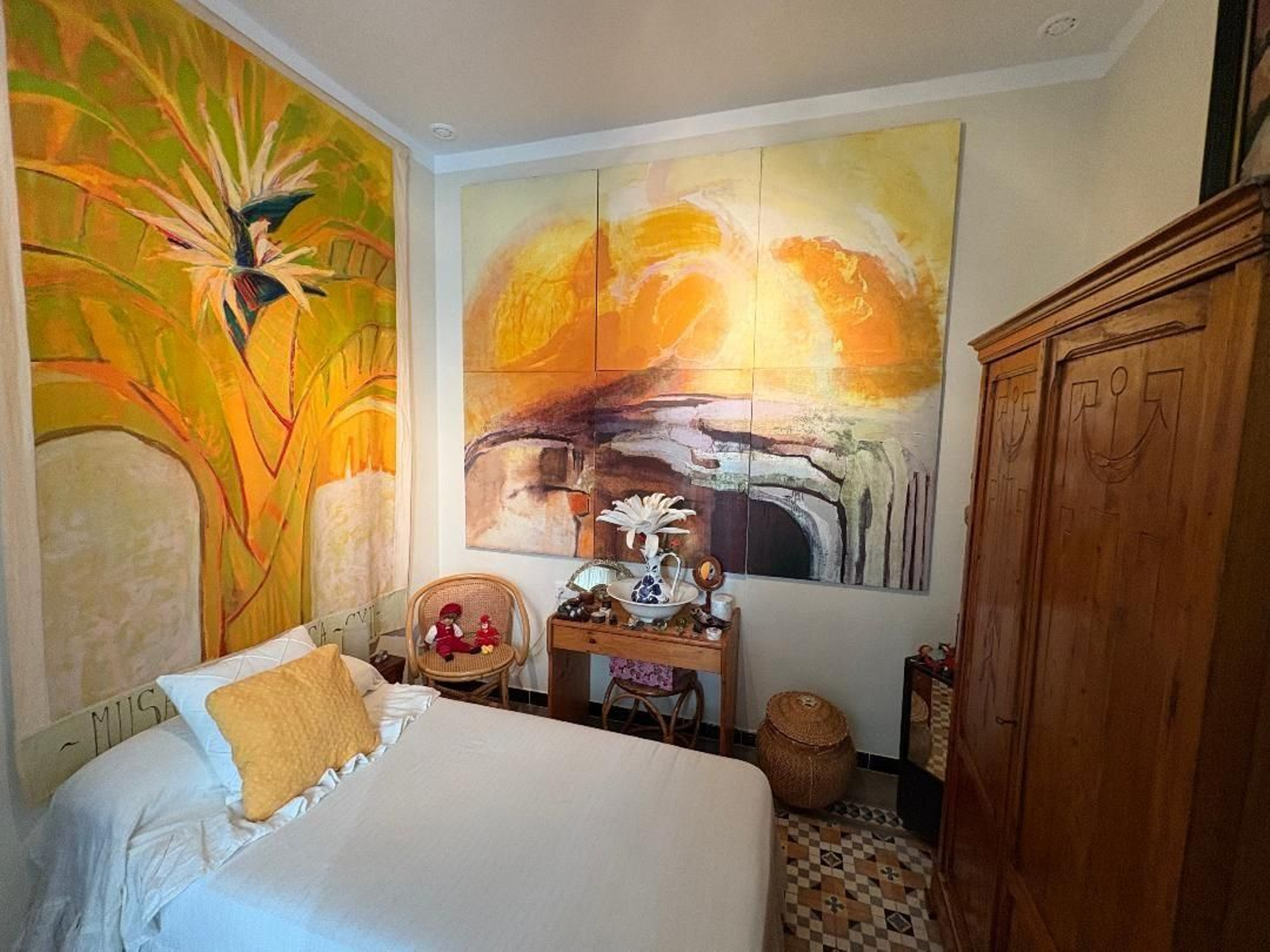 Dormitorio . Pinturas de gran formato de la propietaria junto con un armario de pino de principios del siglo pasado.