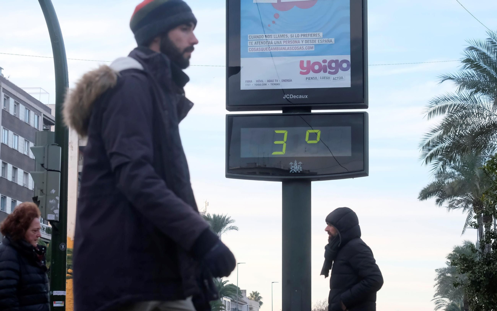 Una persona pasa delante de un termómetro que marca 3 grados en Córdoba.
