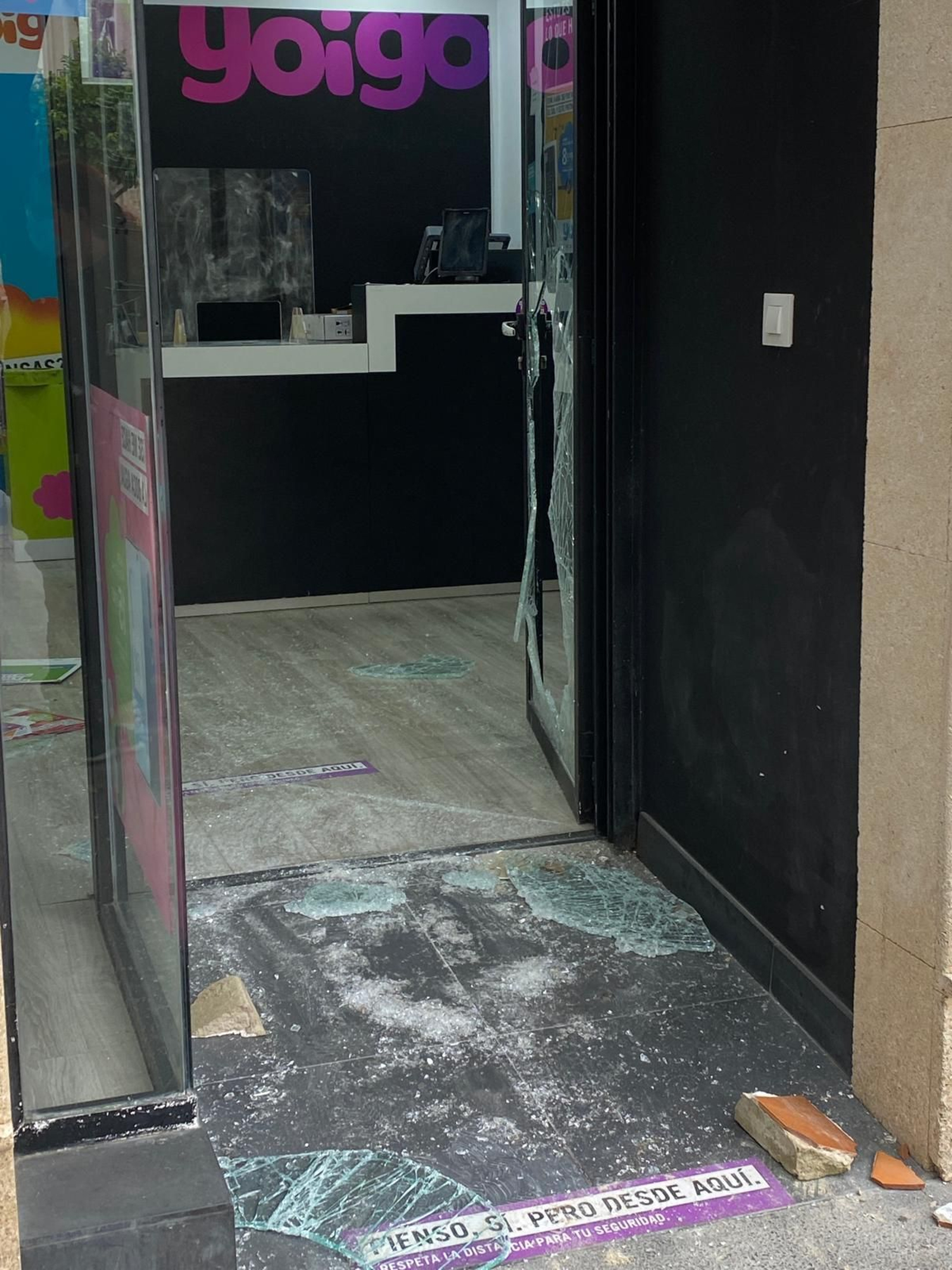 Cristales en el suelo, en la entrada de la tienda de Yoigo.