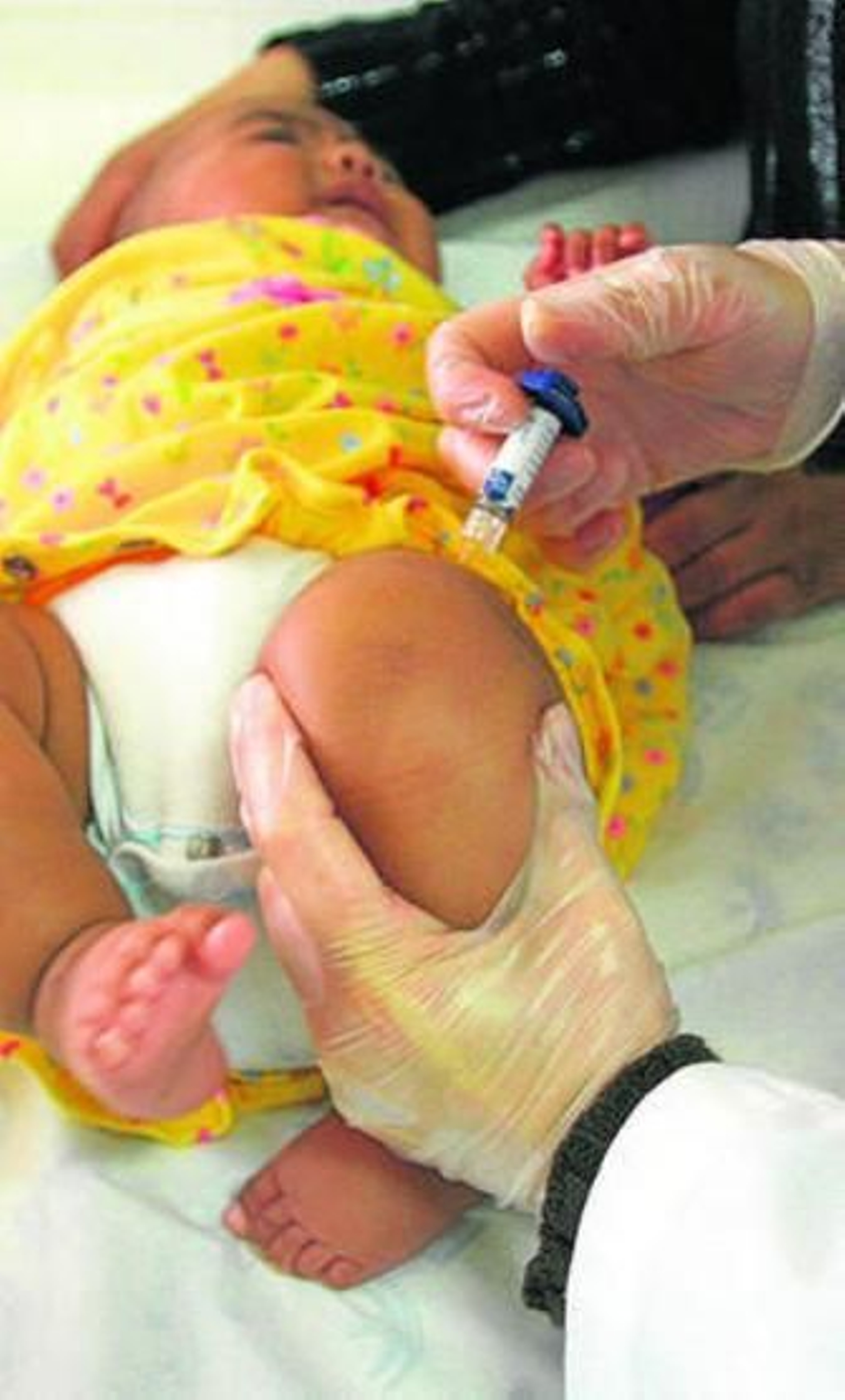 Un pediatra vacuna a una menor.